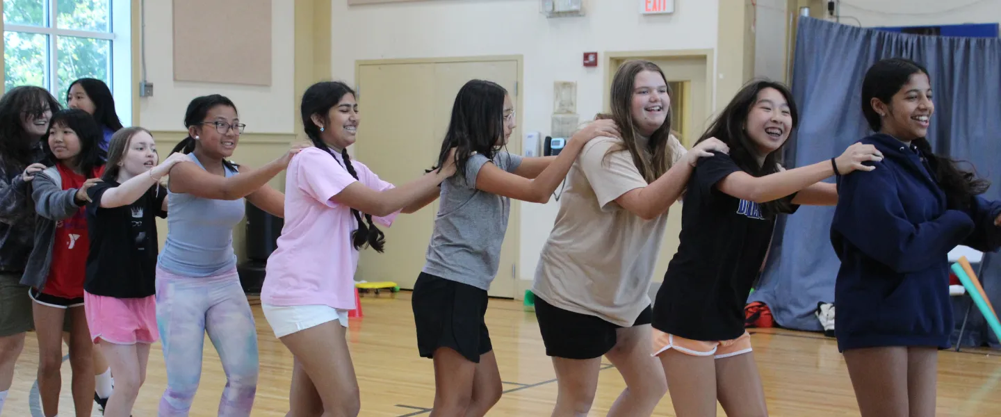 Teens dancing in a conga line at the Bauer Branch