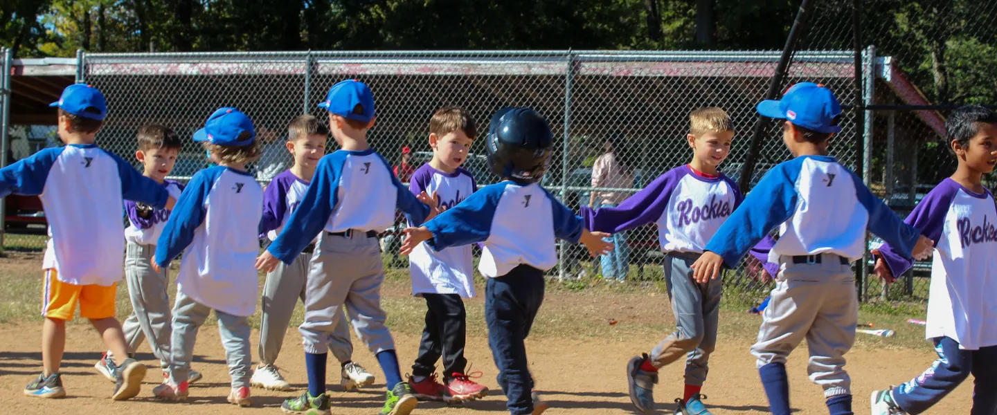 Group of T-Ball players high-five each other after a game.