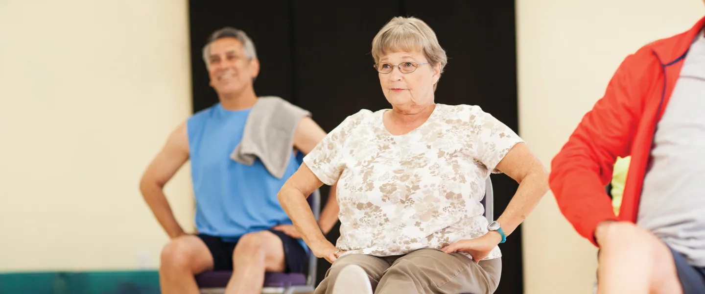 Senior woman participates in a group exercise class.