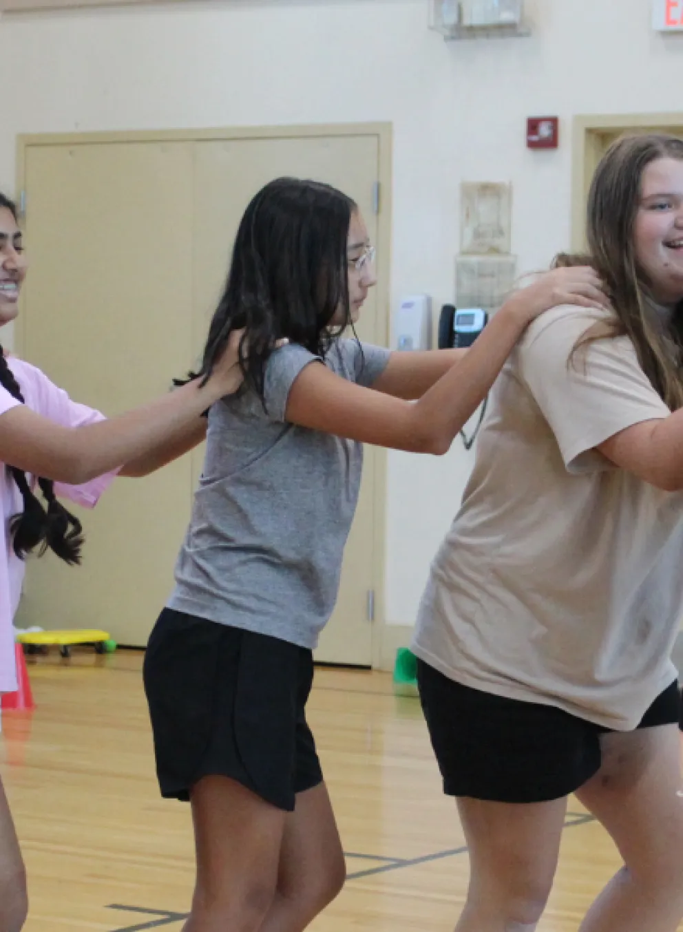 Teens dancing in a conga line at the Bauer Branch