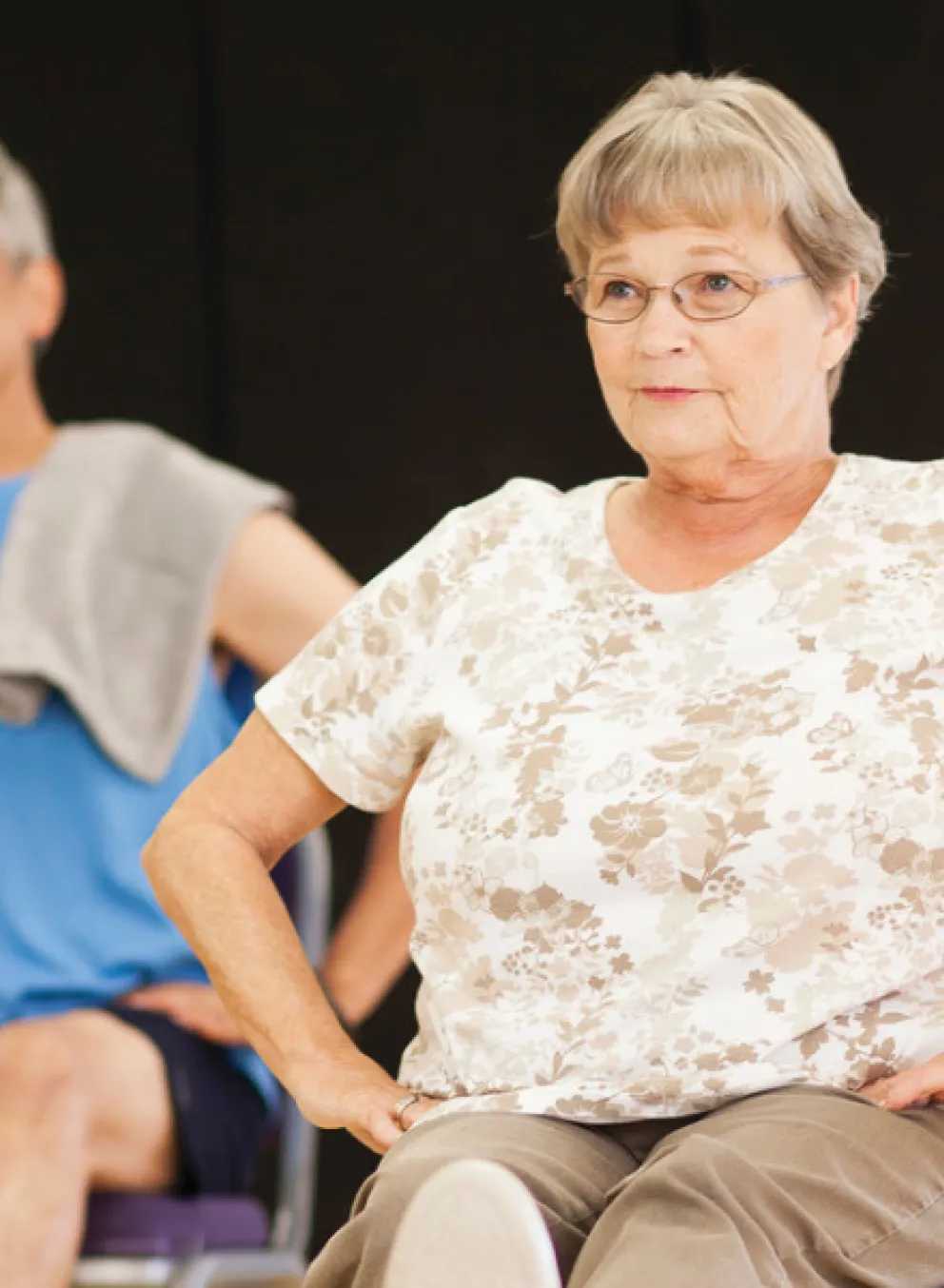 Senior woman participates in a group exercise class.